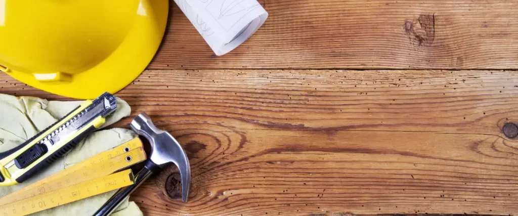 various construction and handyman tools on a rustic wooden deck