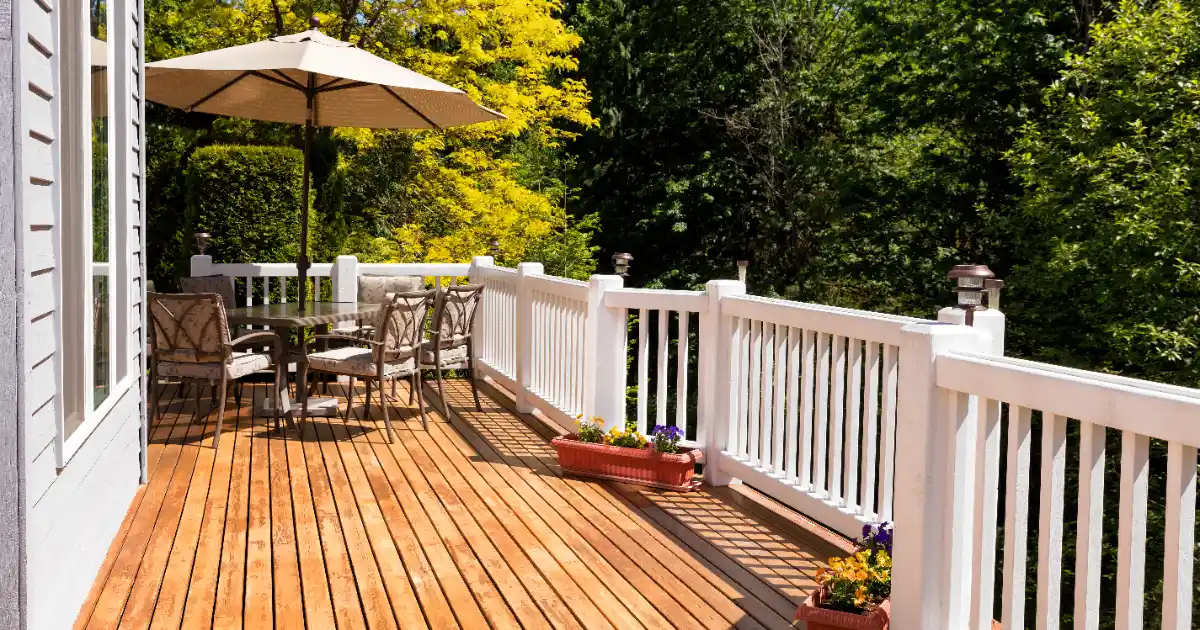 an outdoor cedar deck furnished with a patio dining set and umbrella