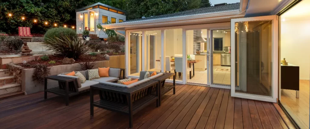 an outdoor wooden deck attached to a modern house, designed for outdoor living and entertainment