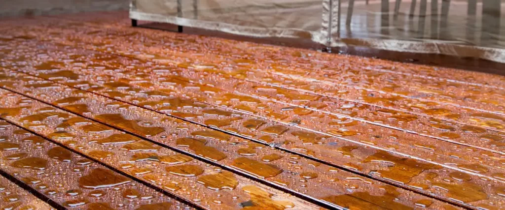 Protecting Your Deck From Hail in Eastern Nebraska Close-up of a well maintained and sealed deck with water pooling in beads on the wooden planks.