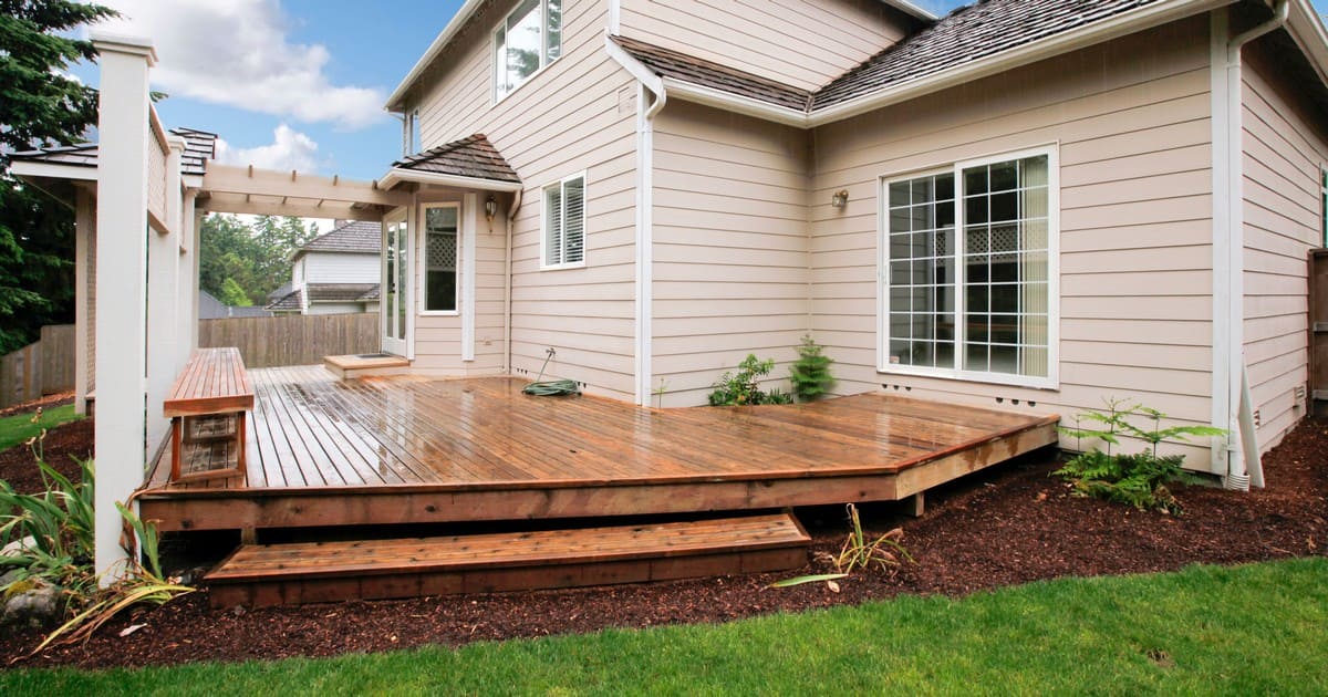 A row of deep concrete pier footings installed in a residential backyard for building decks on expansive clay soil.