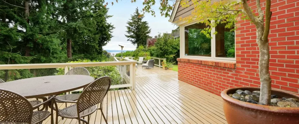 A wide-angle view of a finished pressure-treated pine deck with black metal railings.