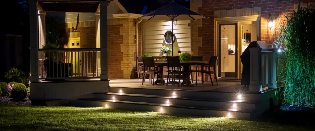 Warm LED deck lighting installed along the stairs and railings for evening ambiance.