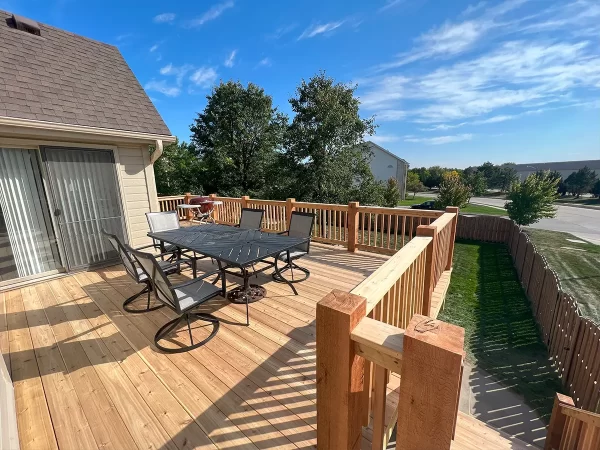 Custom sturdy wooden deck with wooden railing and natural stain in Gertna, NE