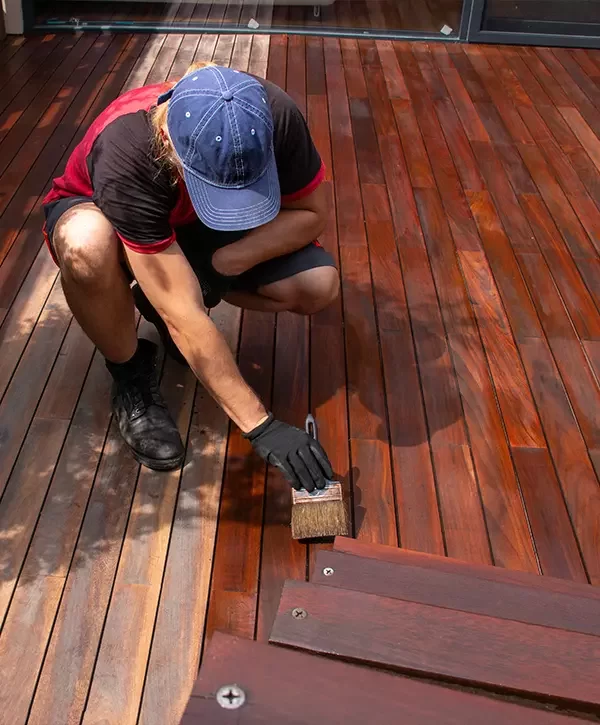 hardwood deck oiling, trade worker applying terrace oil with a brush, decking renovation