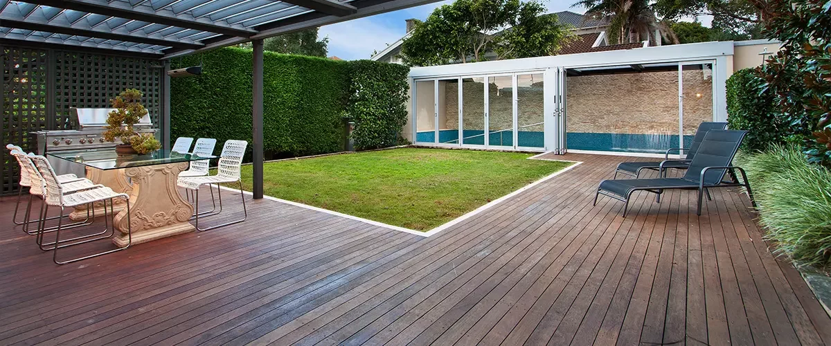 Wood decking on ground level beneath a pergola